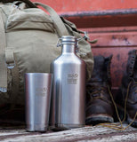 The tall cup is shown lying on a shelf next to a steel water bottle with the same logo on it.