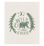 This cream colored dishcloth features a green design of a bear walking between two trees under stars and a moon. The words, "Wild & Free" are shown above and below the bear in green lettering.