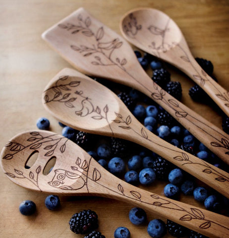 The Solid Beechwood "Nature" sits next to three spoons over blueberries. 