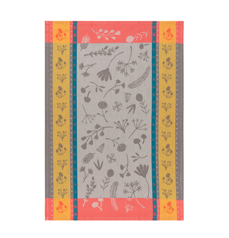 This tea towel has a golden and hot pink edge to it. Plant and leaf designs are shown within the grey center of the towel.