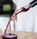 Some wine is shown pouring from a bottle topped with the plastic stopper.