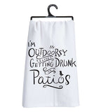 This white dish towel on a hanger contains black text saying, "I'm Outdoorsy I Like Getting Drunk on Patios".