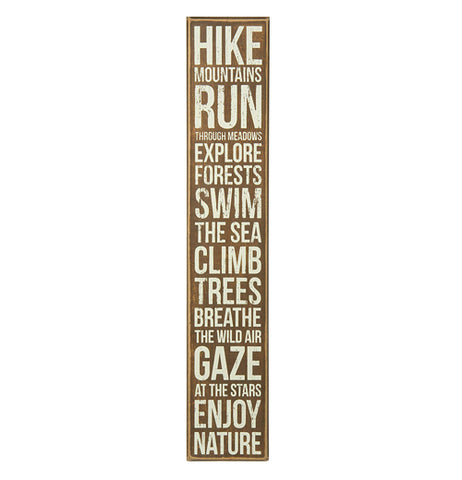 This long and thin brown box sign says the words, "Hike Mountains - Run Through Meadows - Explore Forests - Swim The Sea - Climb Trees - Breathe The Wild Air - Gaze At The Stars - Enjoy Nature" in white lettering.