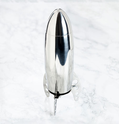Looking down from the side on to a silver rocket shaped Cocktail Shaker standing up on a marble surface on it&