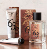 The "Pre De Provence" bottle is shown lying on a table next to its box and a white hand creme container with the same logo and number on it.