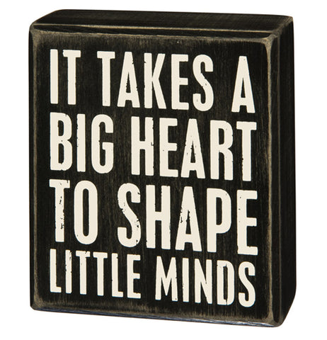This small black wooden box depicts the words, "It Takes A Big Heart To Shape Little Minds" in its center.