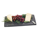 Some cheese and berries are shown sitting on the black cheese board with labels written in chalk.