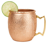 One hammered copper mule mug with a brass handle and a lime slice on the rim.