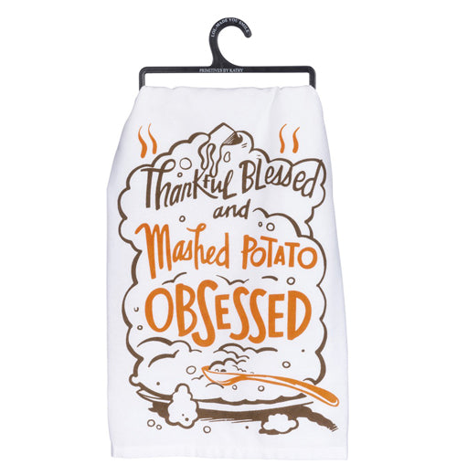White Mashed Potato dish towel with design of a platter of mashed potatoes with spoon and the words "Thankful Blessed and Mashed Potato Obsessed" in brown and orange above.