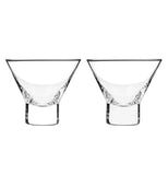 Two clear stemless martini glasses sitting next to each other on a white background.