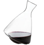 A crystal decanter with a small amount of red wine in it. 