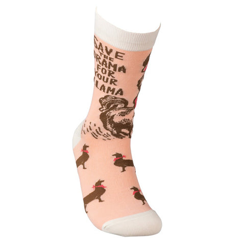 These socks are a light salmon pink with brown llamas wearing red scarfs and hats all around and at the top of the socks. Below the cream colored top are the words, "Save the Drama for Your Llama".