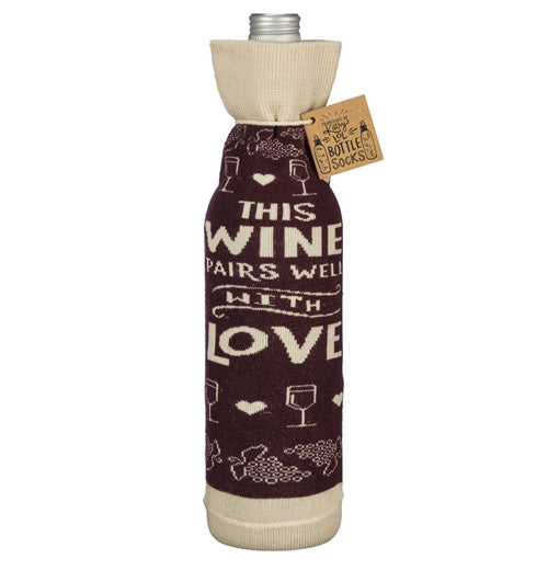 The "Pairs Well" bottle cover reads "This Wine Pairs well with Love" in white over a purple background on a bottle. 