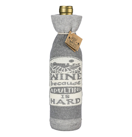 This is one side of the cover showing the white sign with the words, "Wine Because Adulting is Hard" in gray lettering.