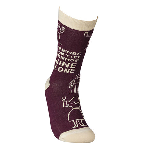 One of the "Wine Alone" socks is on a mannequin foot.