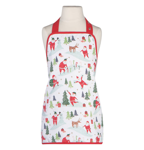 This white apron outlined in red has a design of Santa Claus and reindeer in different poses, including reaching the top of a Christmas tree.