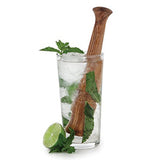 The wood muddler is shown in a drink with ice, leaves, and a lime wedge.