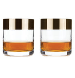 Some liquor is shown inside both the bronze rimmed glasses.