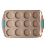 The 12 Cup "Blue" Muffin Pan is on display on a white background. The pan is a bronze color that has 12 cup holes with blue handles. 