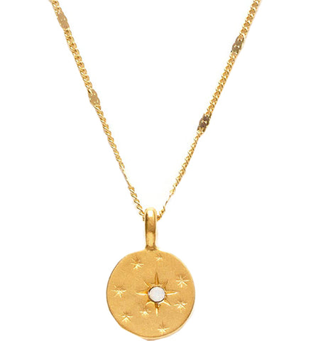A brass necklace with a pendant. The pendant has a star design and an opal stone in the middle.