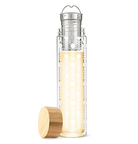 Glass travel mug with floral pattern and stainless steel infuser with its tan bamboo lid laying on its side next to it on a white background.