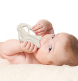 A baby has the Chill Baby "Teether Rex" Teether in their mouth.