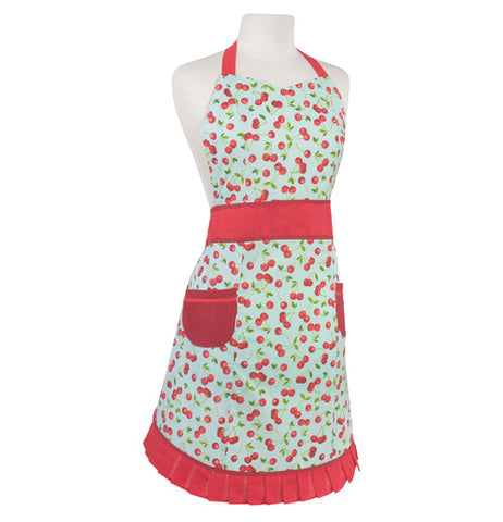 White ladies apron with a red cherry pattern all over, shown hanging on a mannequin bust. It has 2 red pockets at the hip, a red waist band, red neck band, and red ruffle on the bottom edge. 