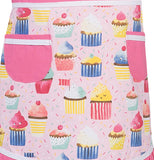 Pastel pink apron with different picture of cupcakes on it. It has pink pockets.