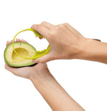 Person moving the avocado scooper into place to scoop out avocado pulp.