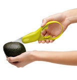 Person using the avocado slicer tool.