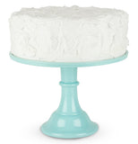 A cake is shown sitting on the mint-colored melamine cake stand.