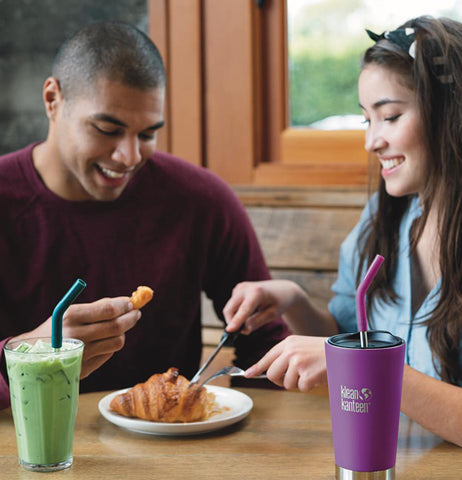 A woman having dinner with her boyfriend with her Insulated Straw Lid Tumbler on the table. 