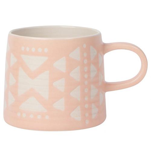 A Pink Mug with white triangles and circles with a pink handle on a white background.