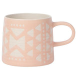 A Pink Mug with white triangles and circles with a pink handle on a white background.