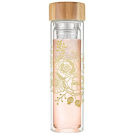 This glass bottle with a wooden lid has a pink metal infuser and features a gold rose stencil design.