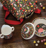The sipping cup with the hedgehog and flower design is shown sitting next to a bowl with a lid, both of which have matching designs.