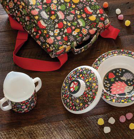 The sipping cup with the hedgehog and flower design is shown sitting next to a bowl with a lid, both of which have matching designs.