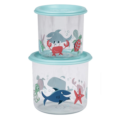 Two different sized clear plastic containers stacked on top of each other, the smaller on top. Each has a light blue lid and silhouettes of sea life such as sharks, starfish, octopus and crabs in red and different shades of blue. To the right is the top view of a container in the packaging. 