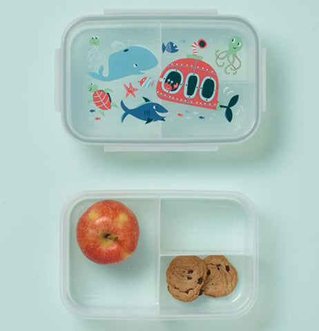 The container's lid wit the ocean design is shown at the top of the image. The container at the bottom of the image is shown with an apple and two cookies.