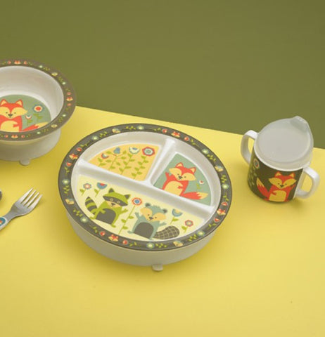 The sipping cup with the fox against the green flower background is shown sitting next to a plate and bowl, both of which have a similar design.