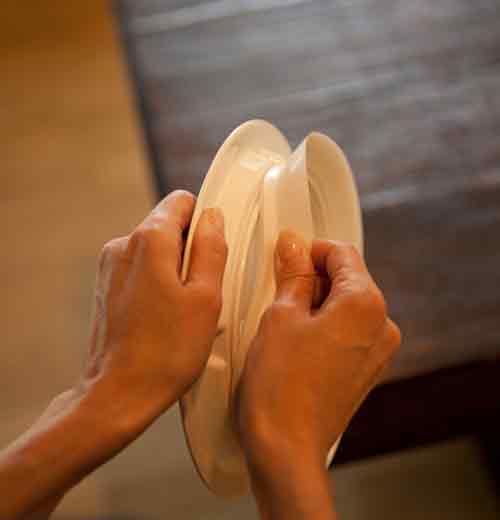 The hands are opening the suction base of the "Baby Otter" baby plate. 