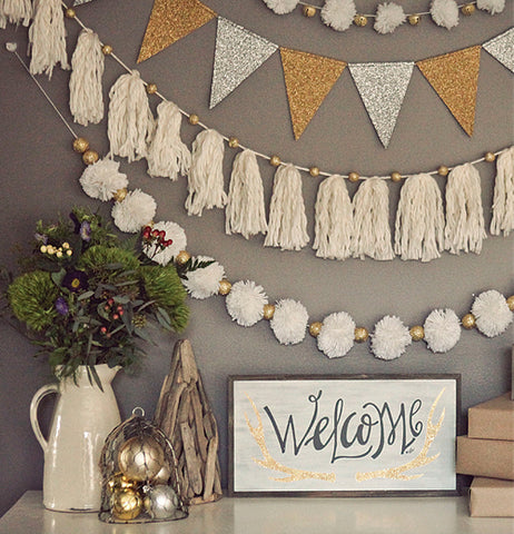 The "Welcome" antlered box sign is shown sitting on a table with some plant holders next to it.