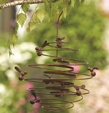 This Double Spiral "Bees" Garden Hanger hands on a tree limb outside the garden. 