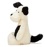a side view of a white puppy with black spots