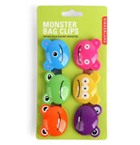 The different colored monster-shaped clips are shown attached to their green packaging. The words, "Monster Bag Clips" are shown above in white lettering.