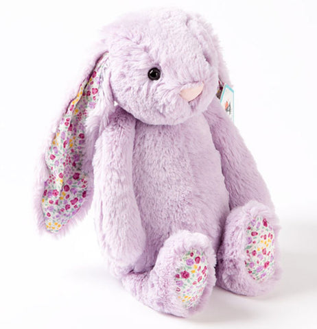 A purple Medium Blossom Jasmine Bunny with pink and purple flowers on its ears and the undersides of its feet sits. 
