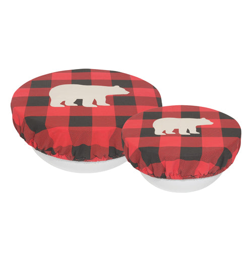 The side view of this set of 2 "Buffalo Check Bear" bowl covers each has a design of a white silhouette of a bear over a black and red plaid pattern and are shown fitting over white bowls. 