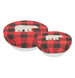 The side view of this set of 2 "Buffalo Check Bear" bowl covers each has a design of a white silhouette of a bear over a black and red plaid pattern and are shown fitting over white bowls. 