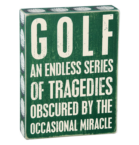 Green wood box sign that says "Golf an endless series of tragedies obscured by the occasional miracle."