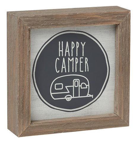 A wooden box sign featuring a trailer with the phase "Happy Camper"